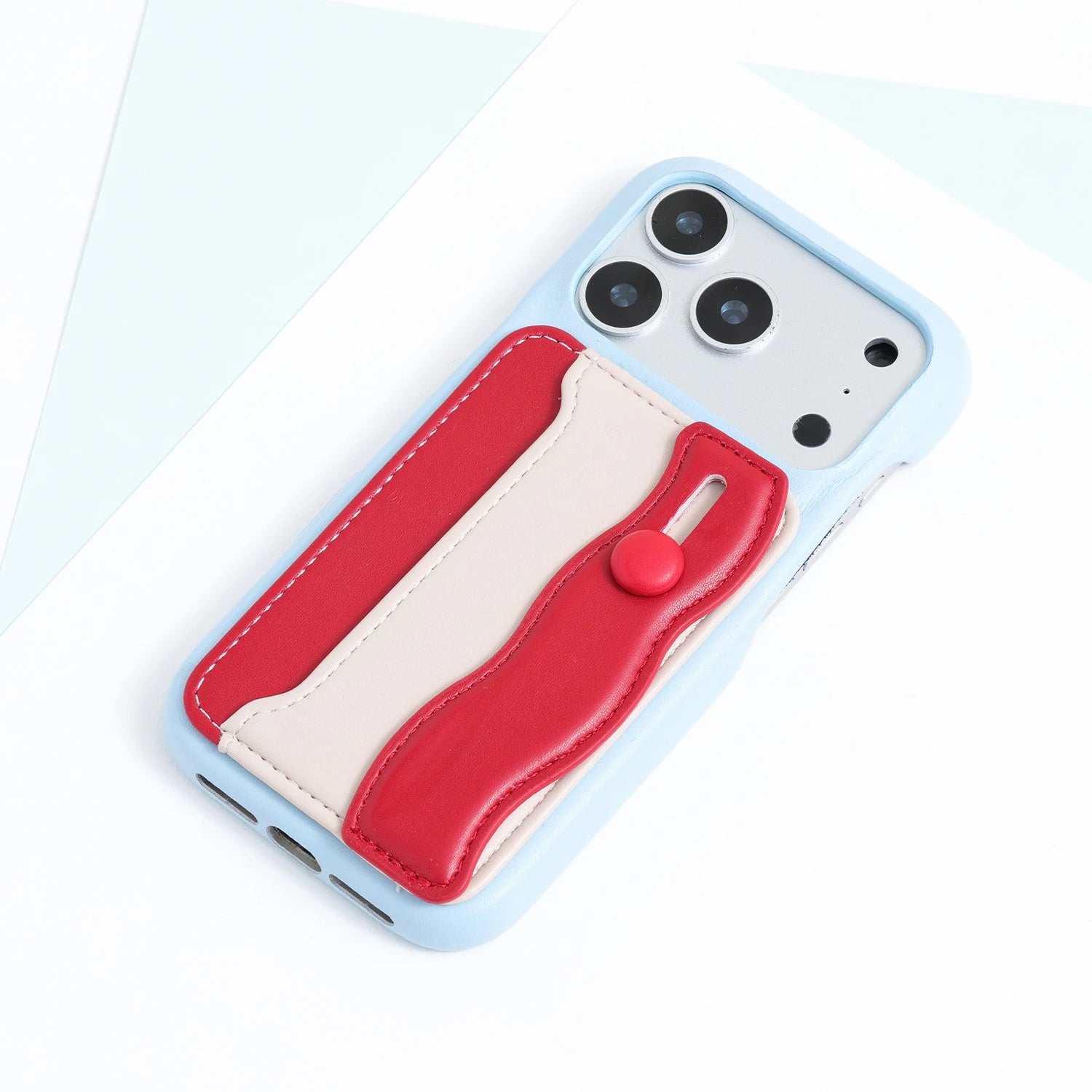 Light blue phone case with a stitched red and ivory card pocket panel and fold-back strap detail on the back.