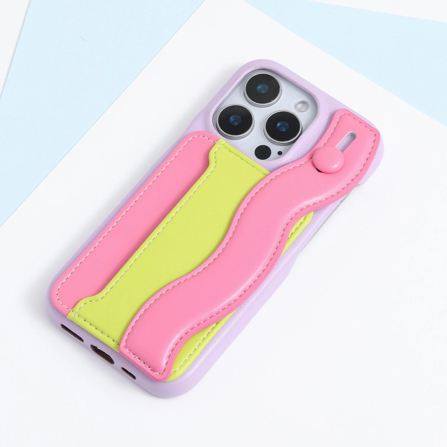 Lilac phone case with a pink and lime stitched card pocket panel and curved fold-back strap.