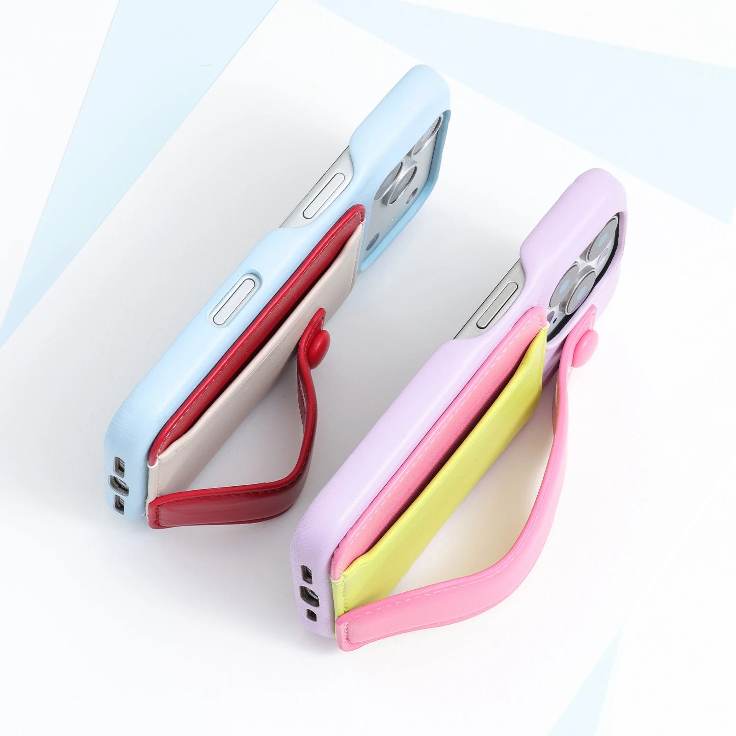Side view of two phone cases with fold-back straps opened to function as viewing stands.