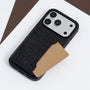 Close-up of a black crocodile-embossed phone case with a card partially inserted into the back pocket.