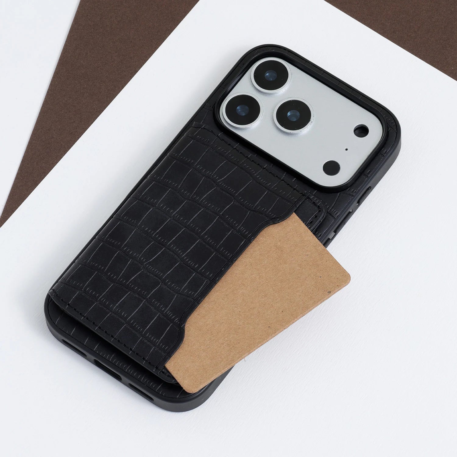 Close-up of a black crocodile-embossed phone case with a card partially inserted into the back pocket.