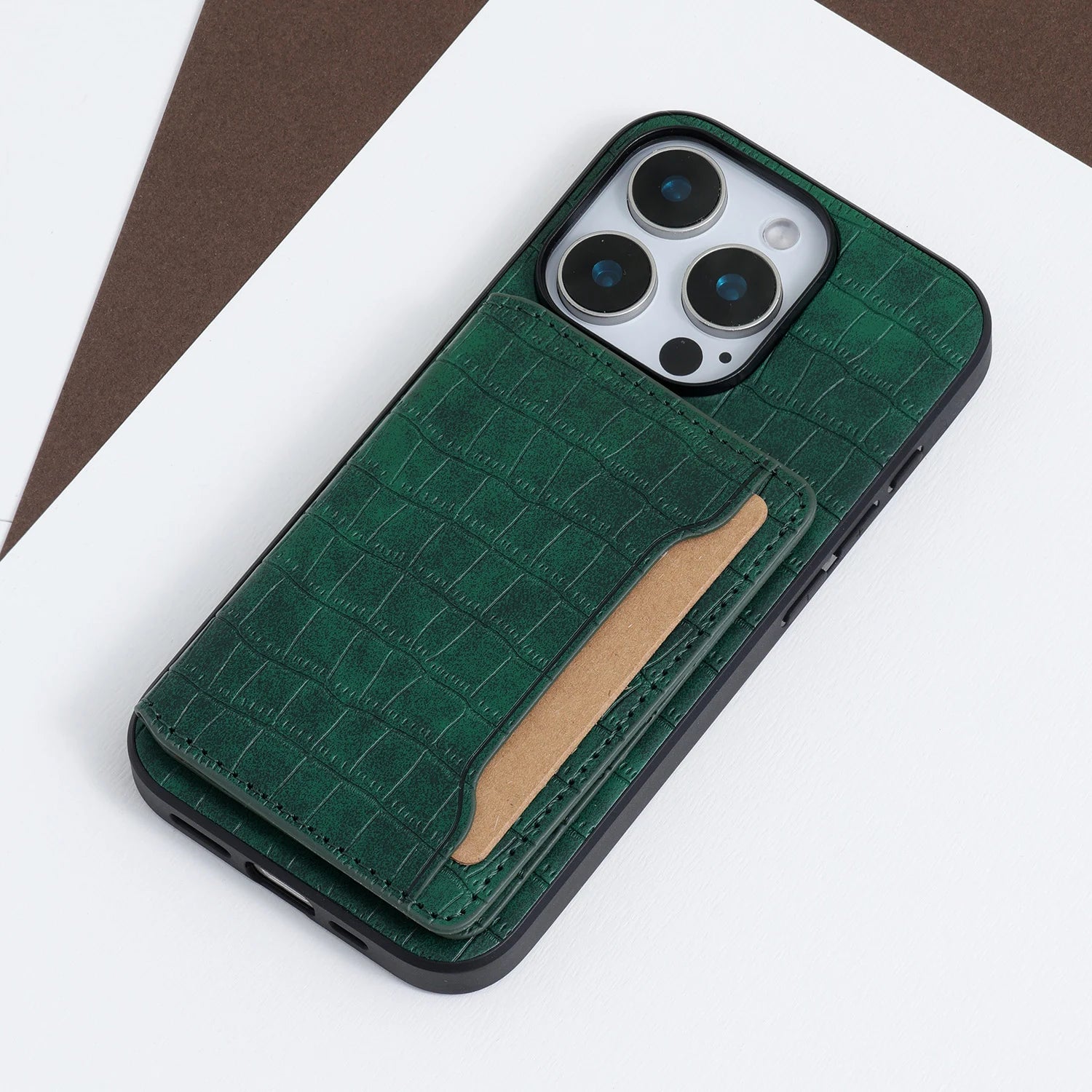 Close-up of a green croco phone case showing the textured card pocket and raised camera protection.