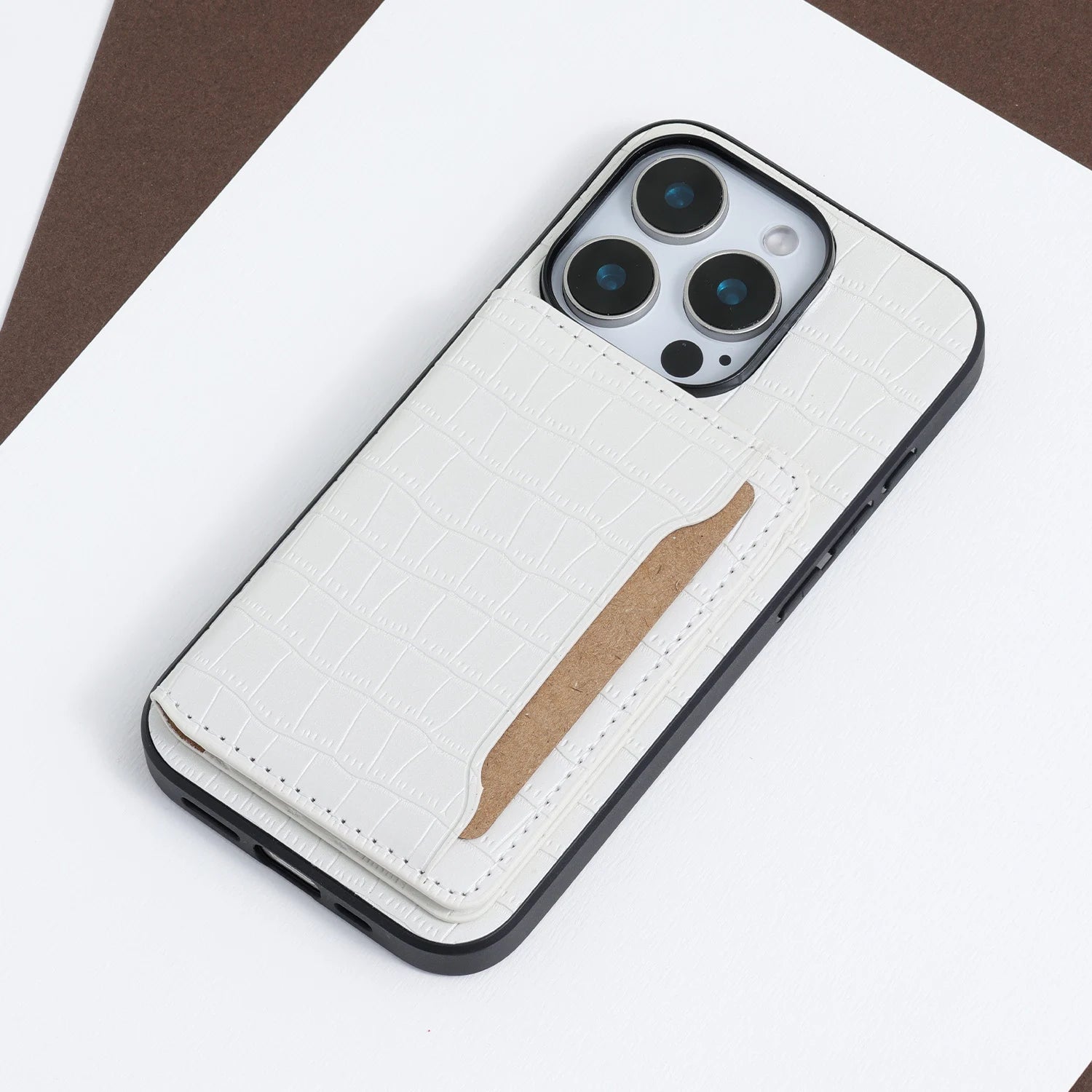 White crocodile-embossed phone case with a stitched card holder panel and slim structured silhouette.