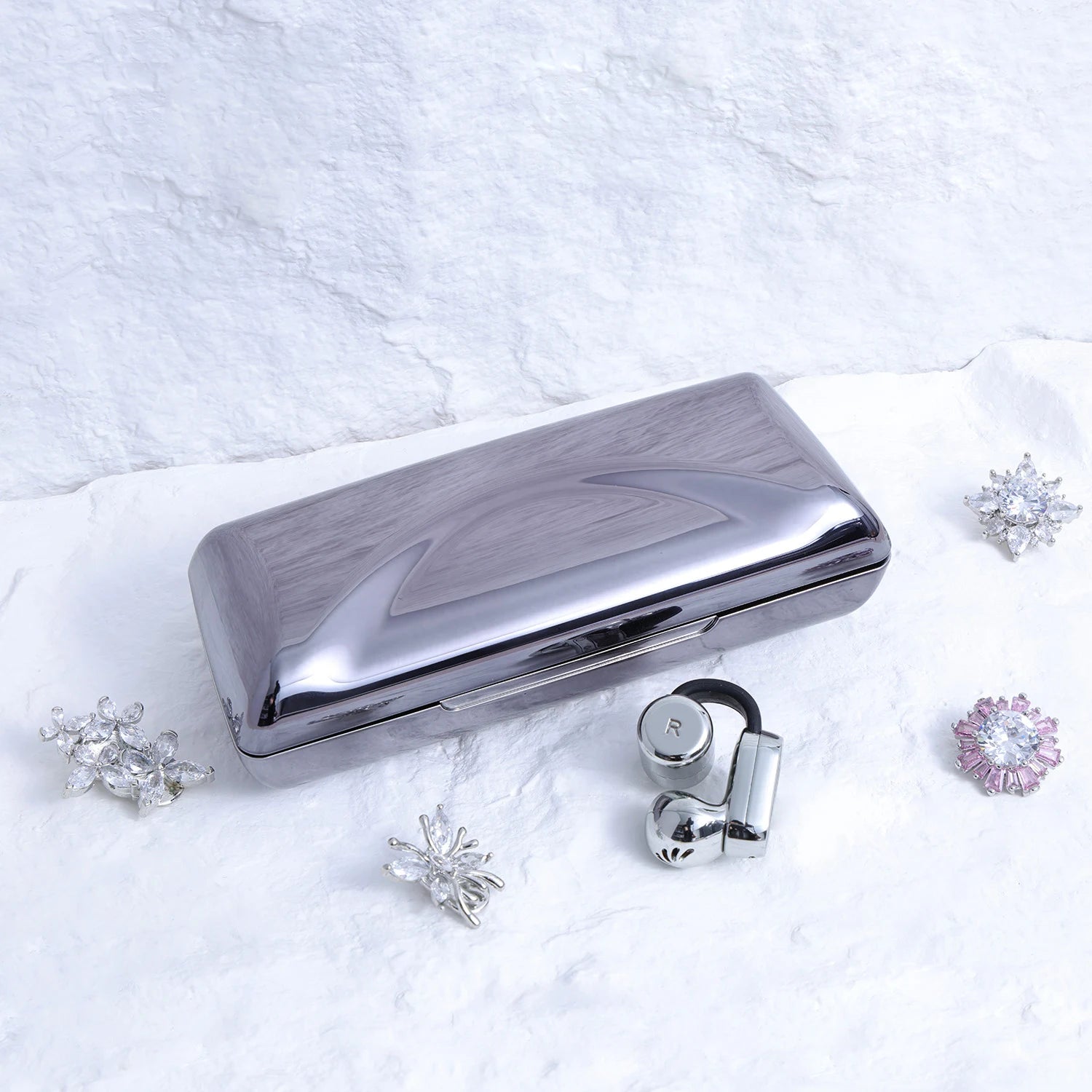 Close-up of Interstella Crystal Aura Bluetooth ear jewelry showing interchangeable crystal accessories and magnetic attachment