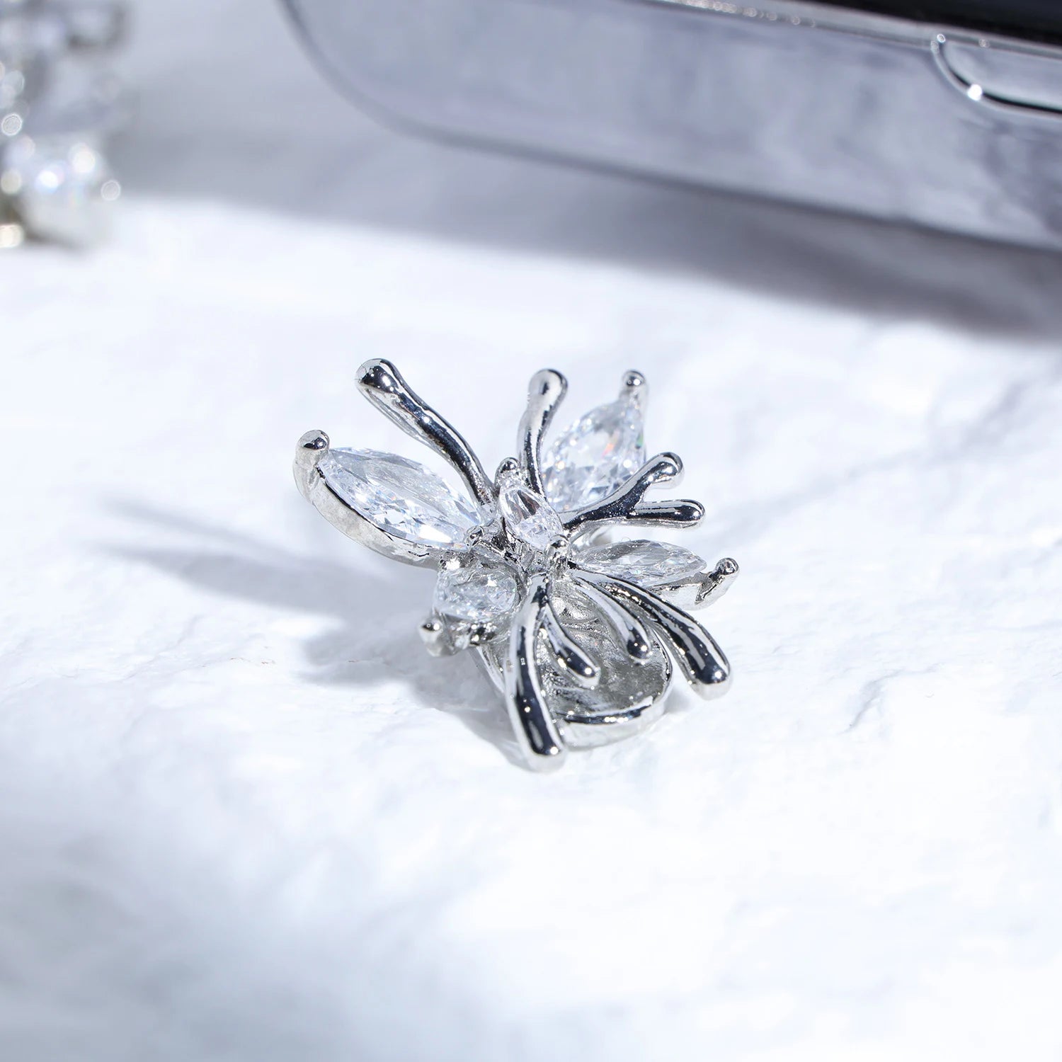 Close-up of Interstella Crystal Aura Bluetooth ear jewelry showing interchangeable crystal accessories and magnetic attachment