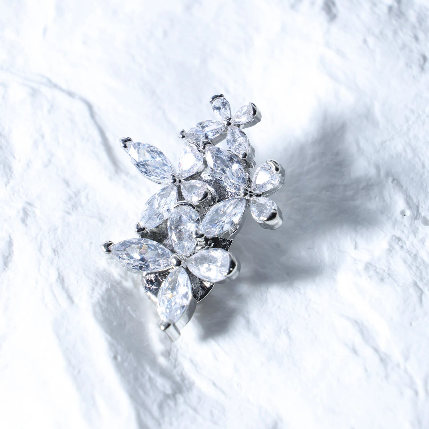 Close-up of Interstella Crystal Aura Bluetooth ear jewelry showing interchangeable crystal accessories and magnetic attachment