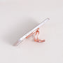 Rose gold MagSafe expandable metal ring stand attached to iPhone, sculptural circular design