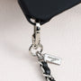 Close-up of metal logo charm and hardware attached to structured TPU phone case
