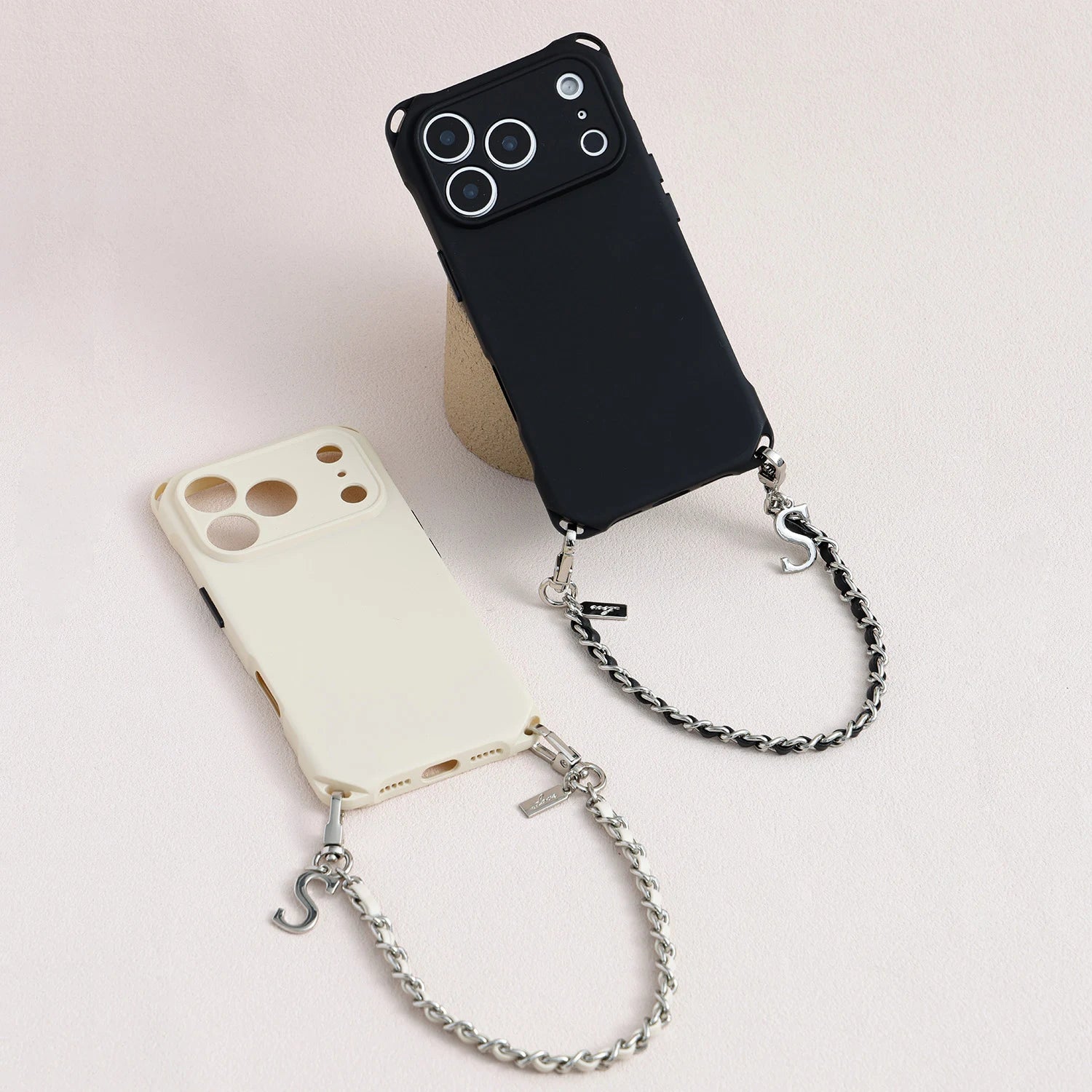 Two sculpted TPU phone cases shown with matching detachable leather-woven metal chains