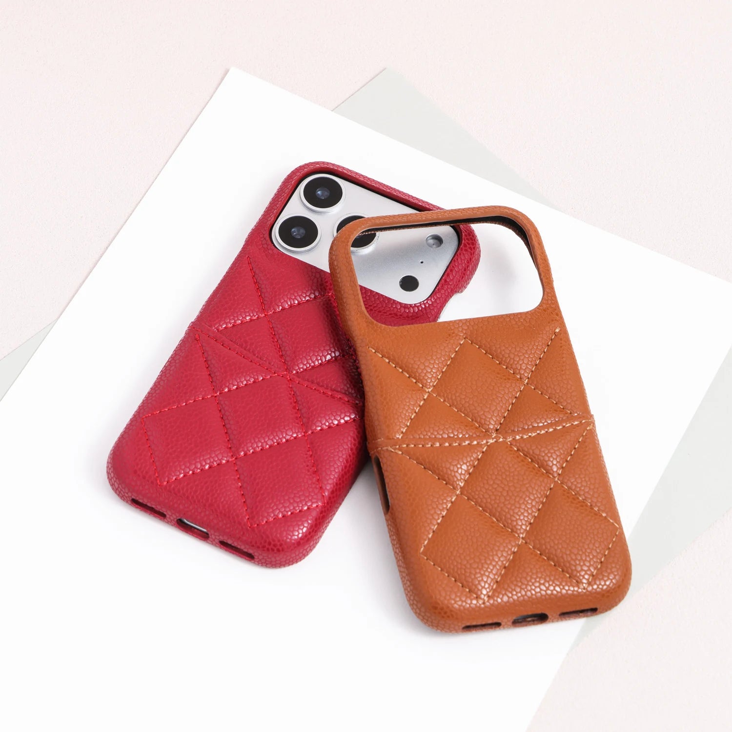 Scarlet red quilted leather phone case on a phone beside a caramel tan case shell.