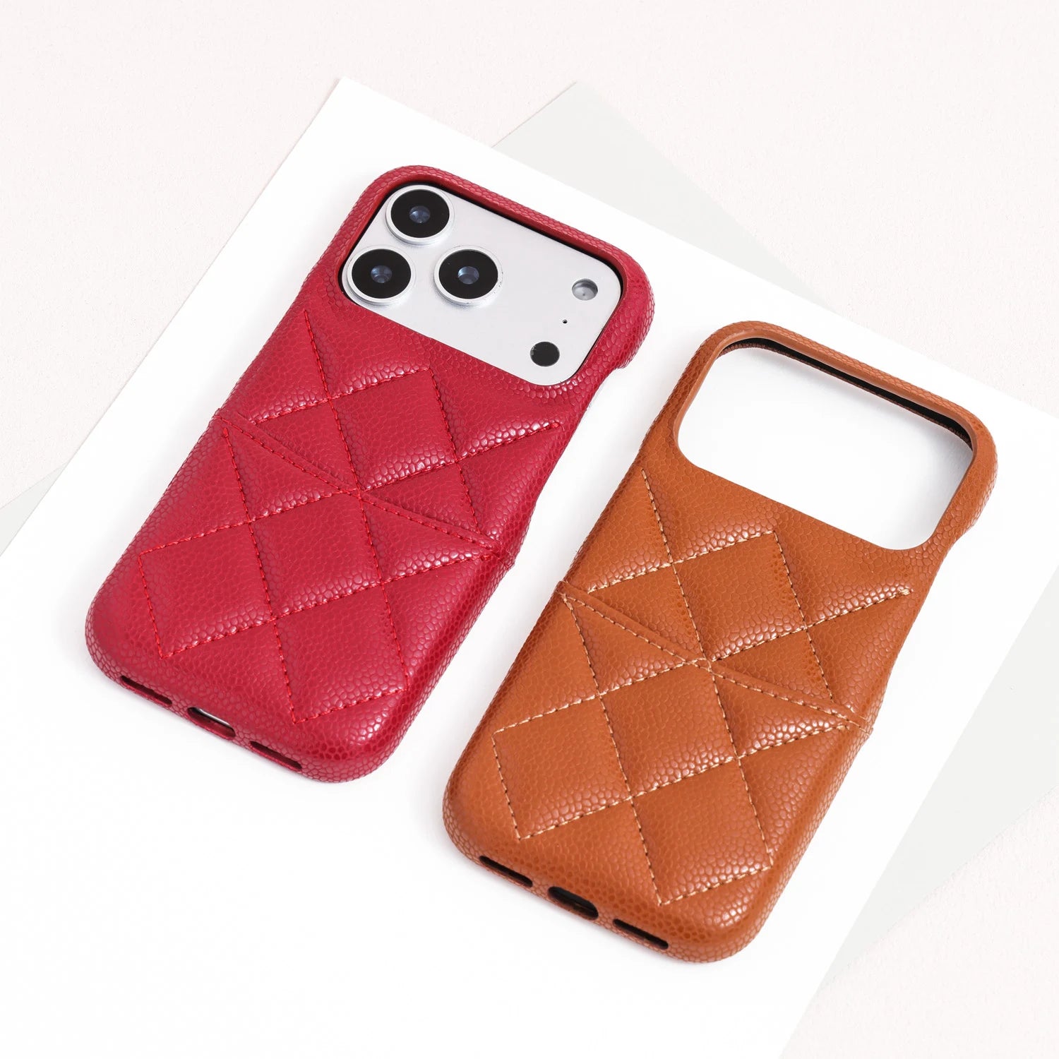 Red and caramel quilted leather phone cases displayed side by side on a neutral background.