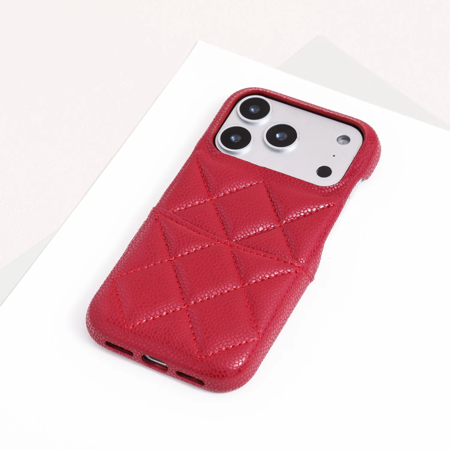 Single scarlet red quilted leather phone case fitted on a phone.