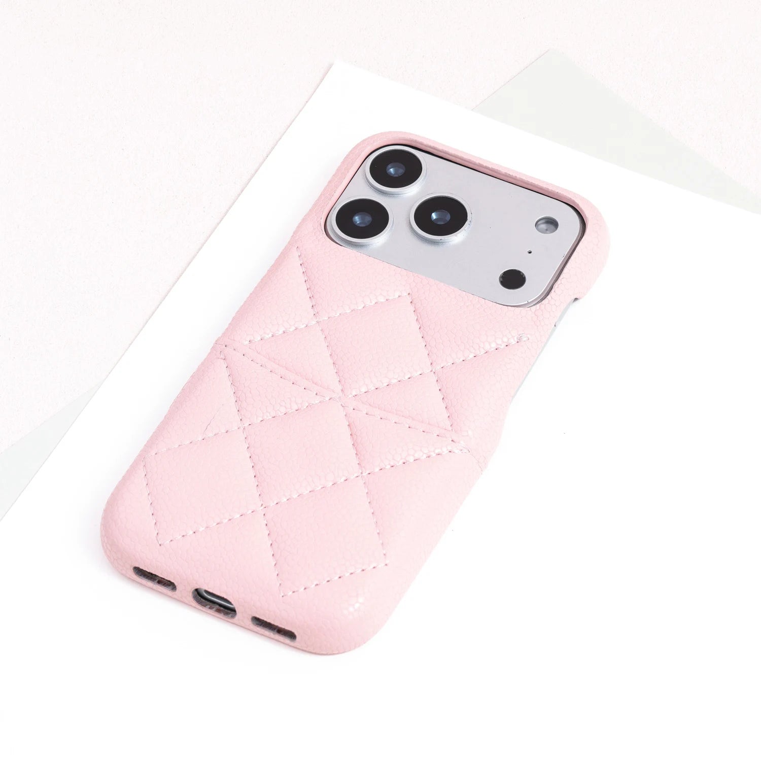 Single powder pink quilted leather phone case with soft geometric stitching.