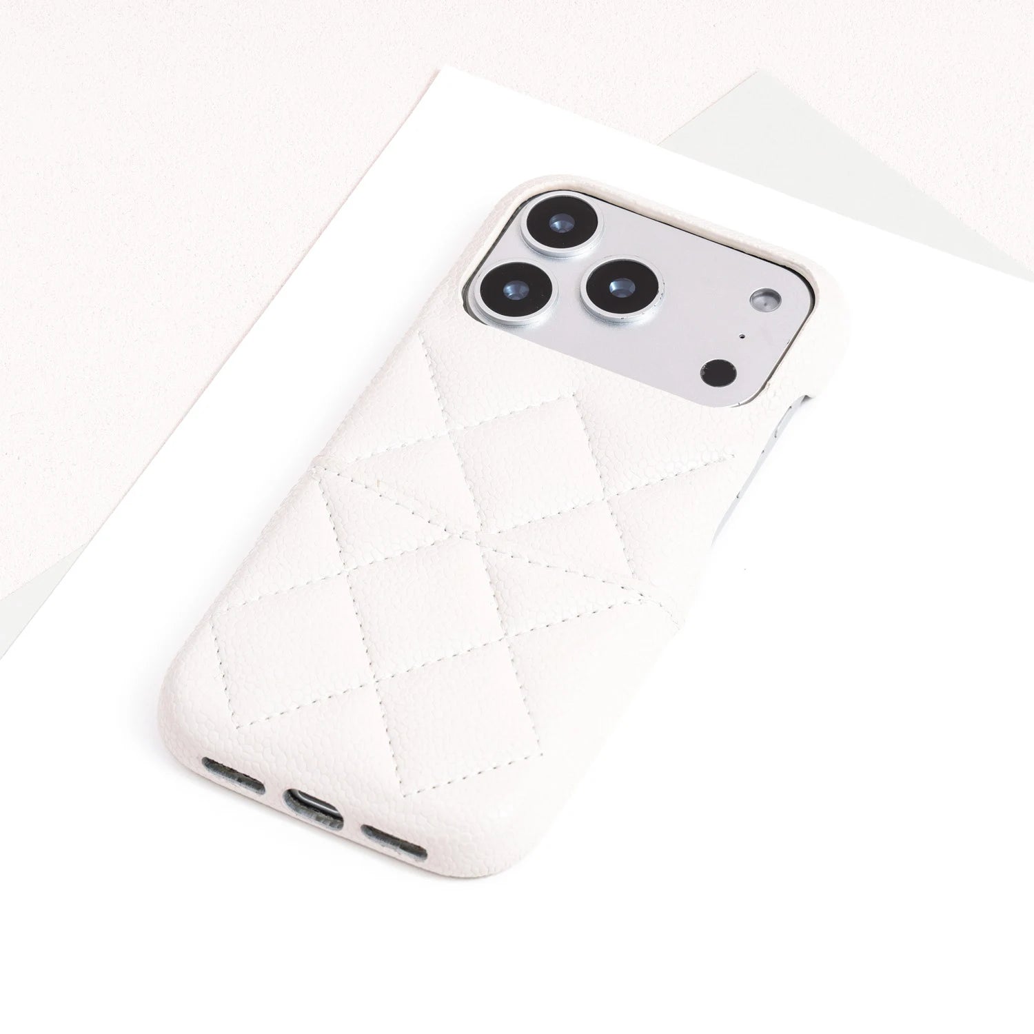 Single ivory quilted leather phone case with minimalist textured finish.