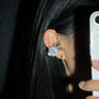 Woman wearing Interstella Crystal Aura Bluetooth ear jewelry, combining crystal accessories with open-ear wireless sound