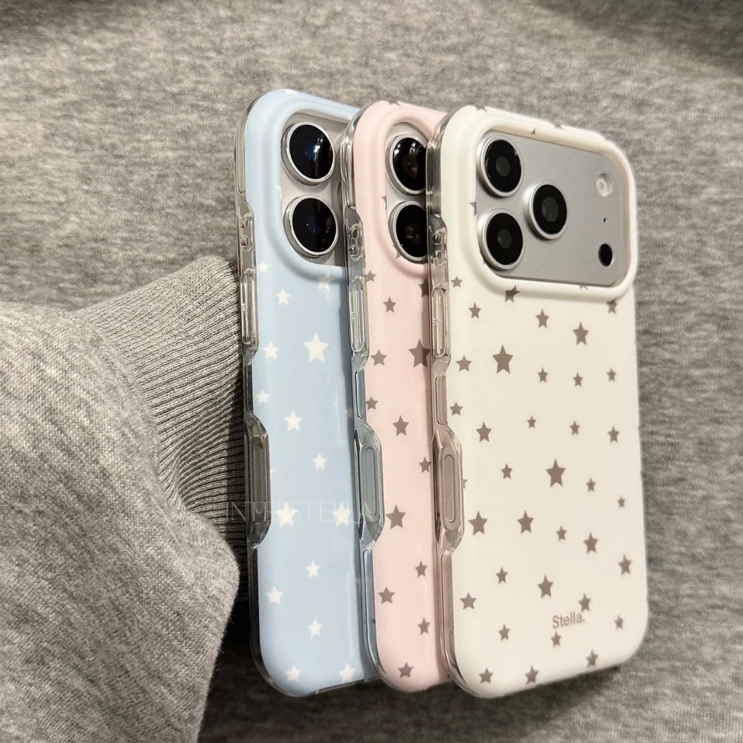 Side view of white, blush pink, and baby blue matte star phone cases with clear edges