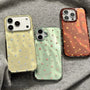 Three glossy star phone cases in gold, mint green, and deep red displayed on grey fabric