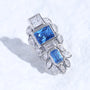 Blue gemstone ear charm with Swarovski crystal accents and silver-tone plated reliquary silhouette on a white textured surface