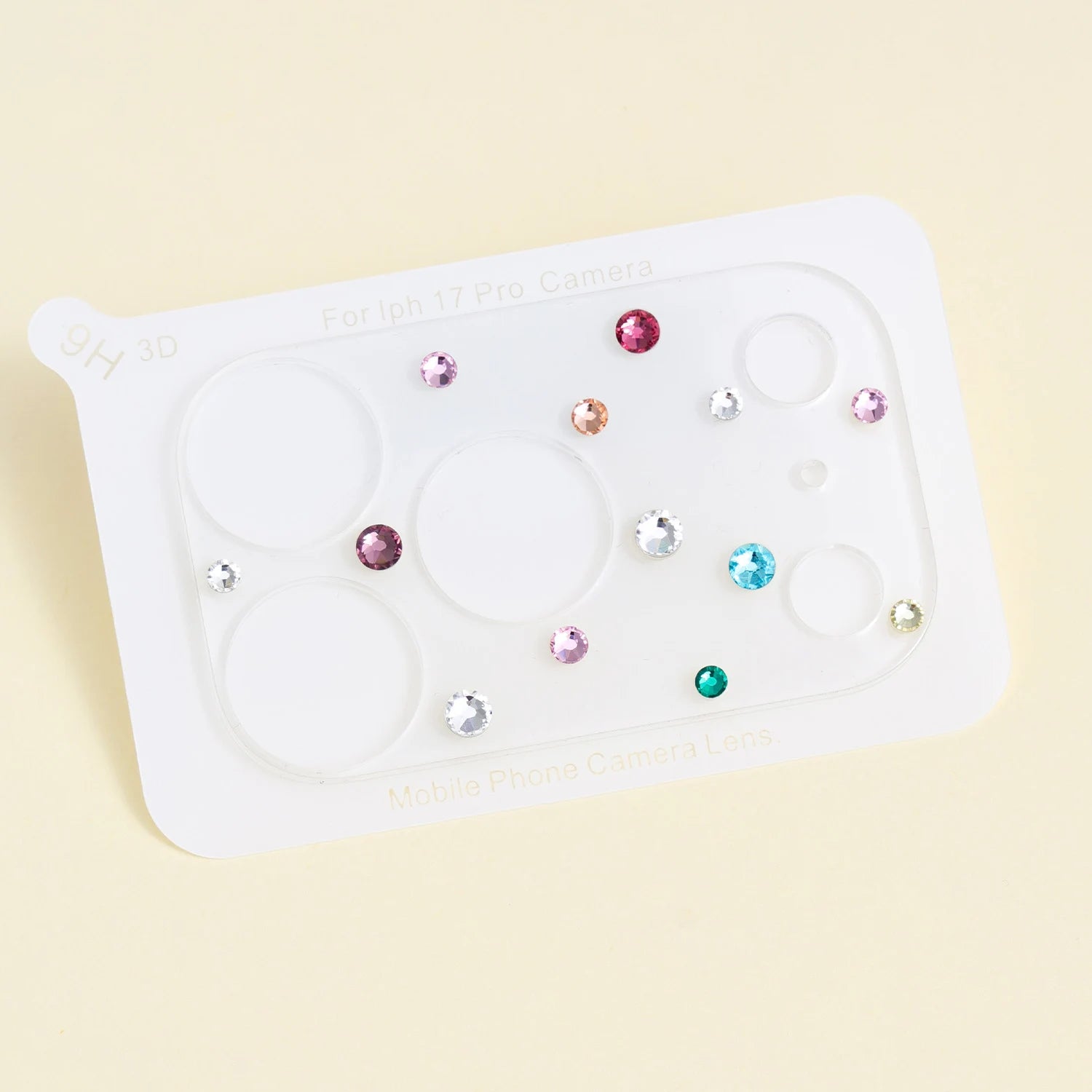 Clear acrylic camera lens protector sheet decorated with multicolor crystals in pink, blue, green, champagne, and clear tones.