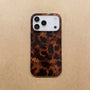 Tortoiseshell leopard phone case laid flat on a beige textured background