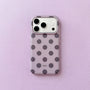 Lilac polka dot phone case with charcoal grey dots and raised camera surround on a soft lavender background.