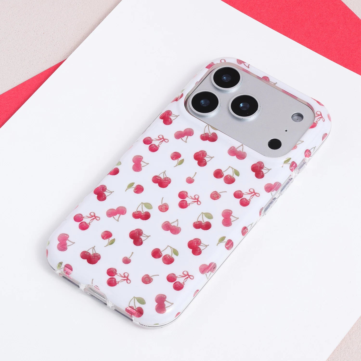 Full view of a white TPU phone case with miniature red cherry illustrations and a clean vintage-inspired fruit pattern.