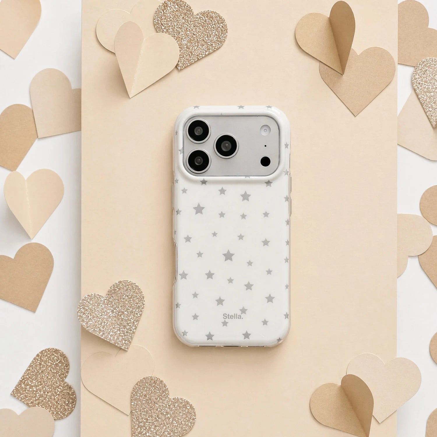 White matte star phone case with silver star print on a beige heart backdrop