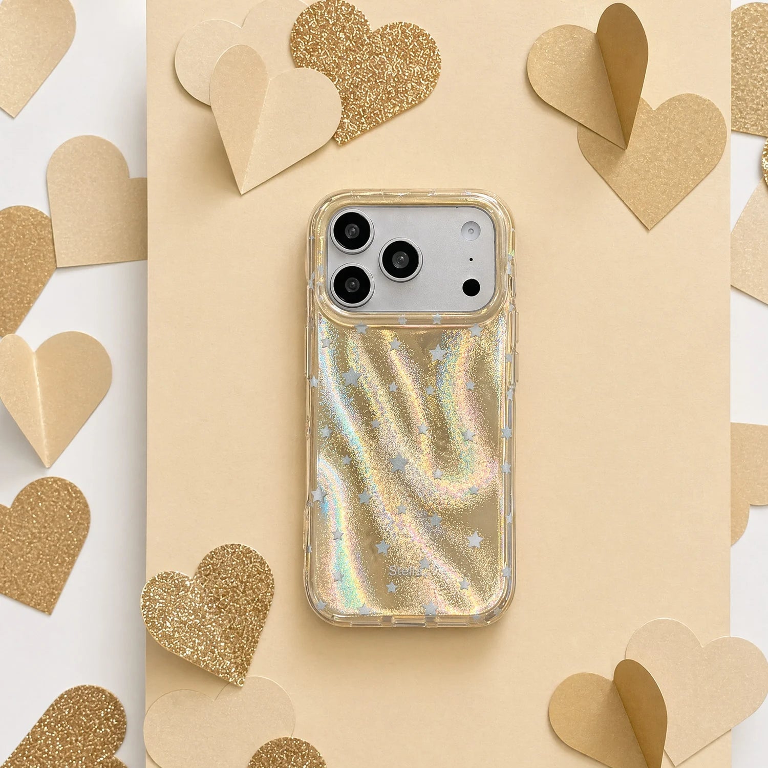 Champagne gold shimmer star phone case with silver stars on a warm beige heart backdrop