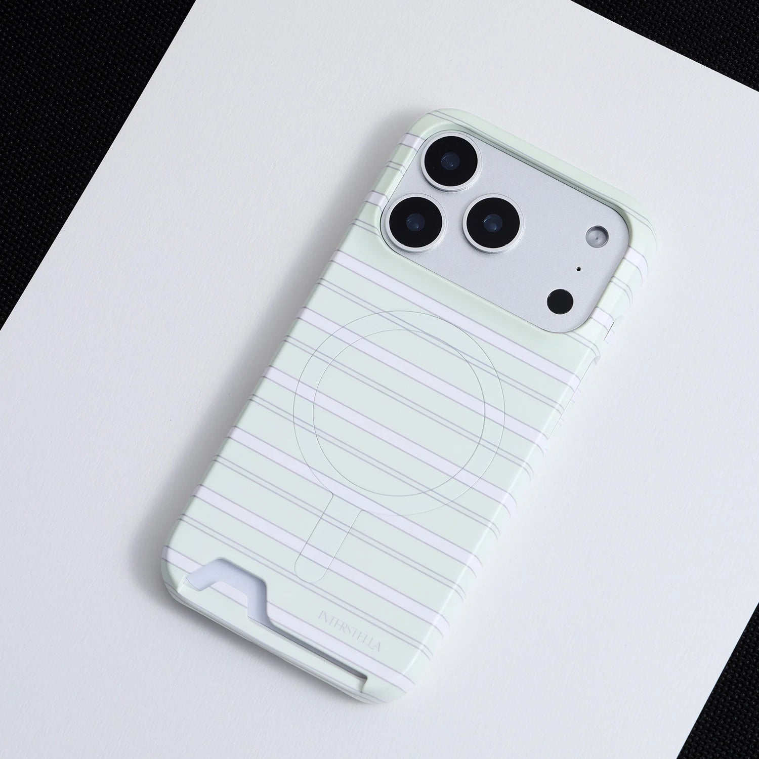 Angled view of mint striped hard-shell phone case with built-in back card slot