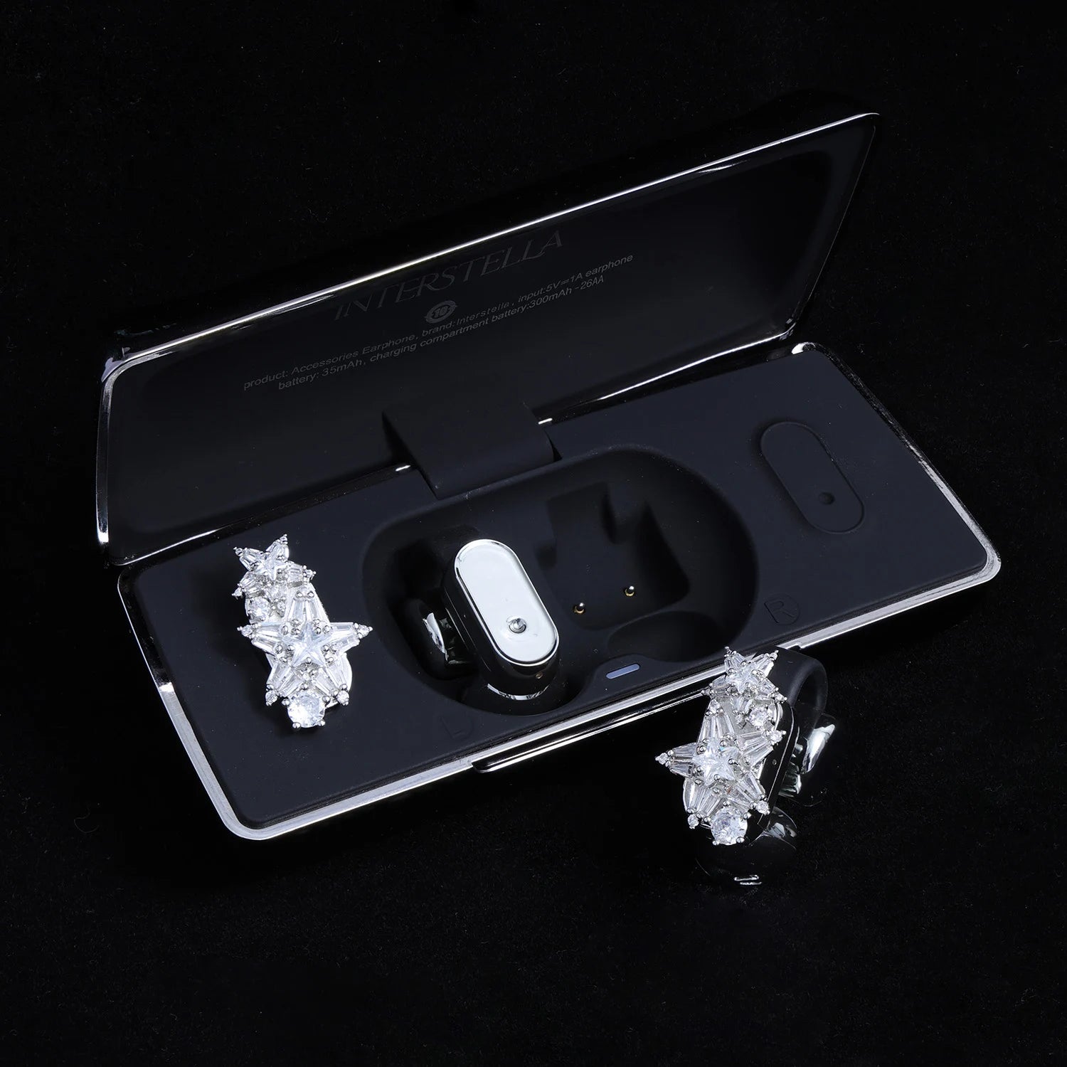 Starburst crystal ear charms displayed with black Interstella magnetic earphone charging case