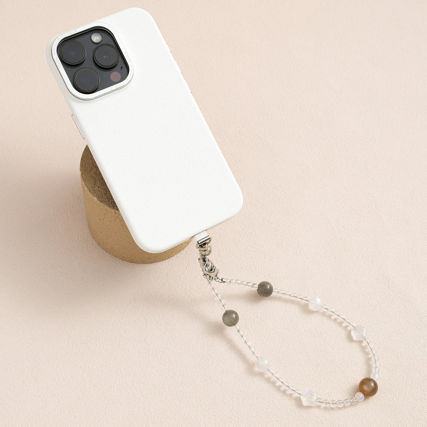 Grey moonstone, white quartz and peach moonstone gemstone phone strap with custom metal link clasp, handmade detachable bracelet phone strap on a neutral background.