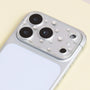 Silver crystal acrylic camera lens protector installed on a silver iPhone, showing delicate rhinestone accents around the camera area.