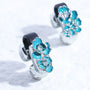 Pair of turquoise blossom magnetic ear charms shown attached to Interstella Aura earbuds, featuring glossy enamel petals and clear crystal centers.