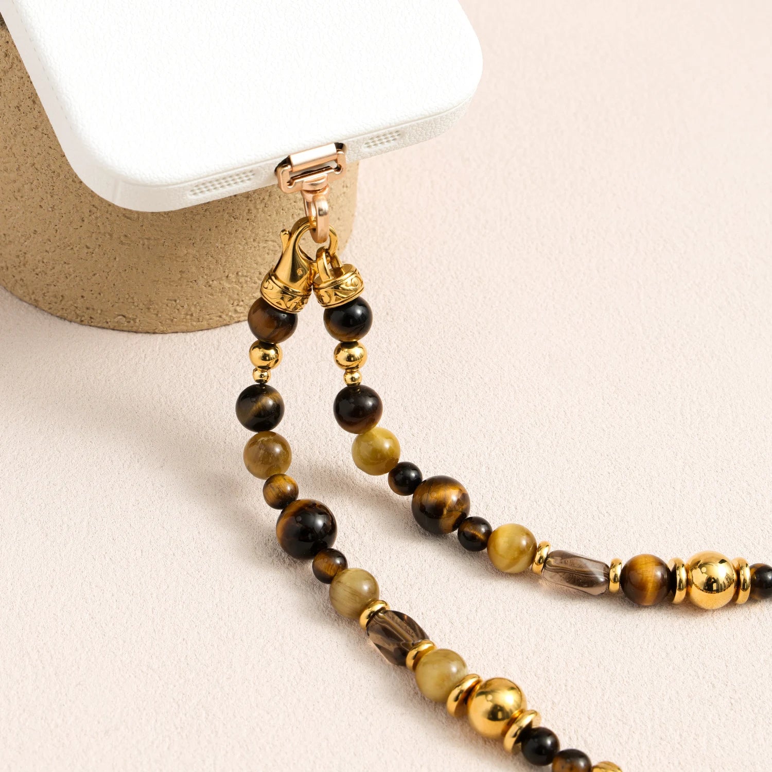 Tiger’s eye gemstone phone strap with gold metal accents, detachable bracelet design