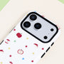 Close-up of an orchard-inspired apple print phone case showing the white background, red fruit motifs, colorful stars, and black raised camera frame.
