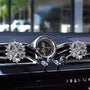 Luxury crystal car diffuser displayed on a beige stone pedestal