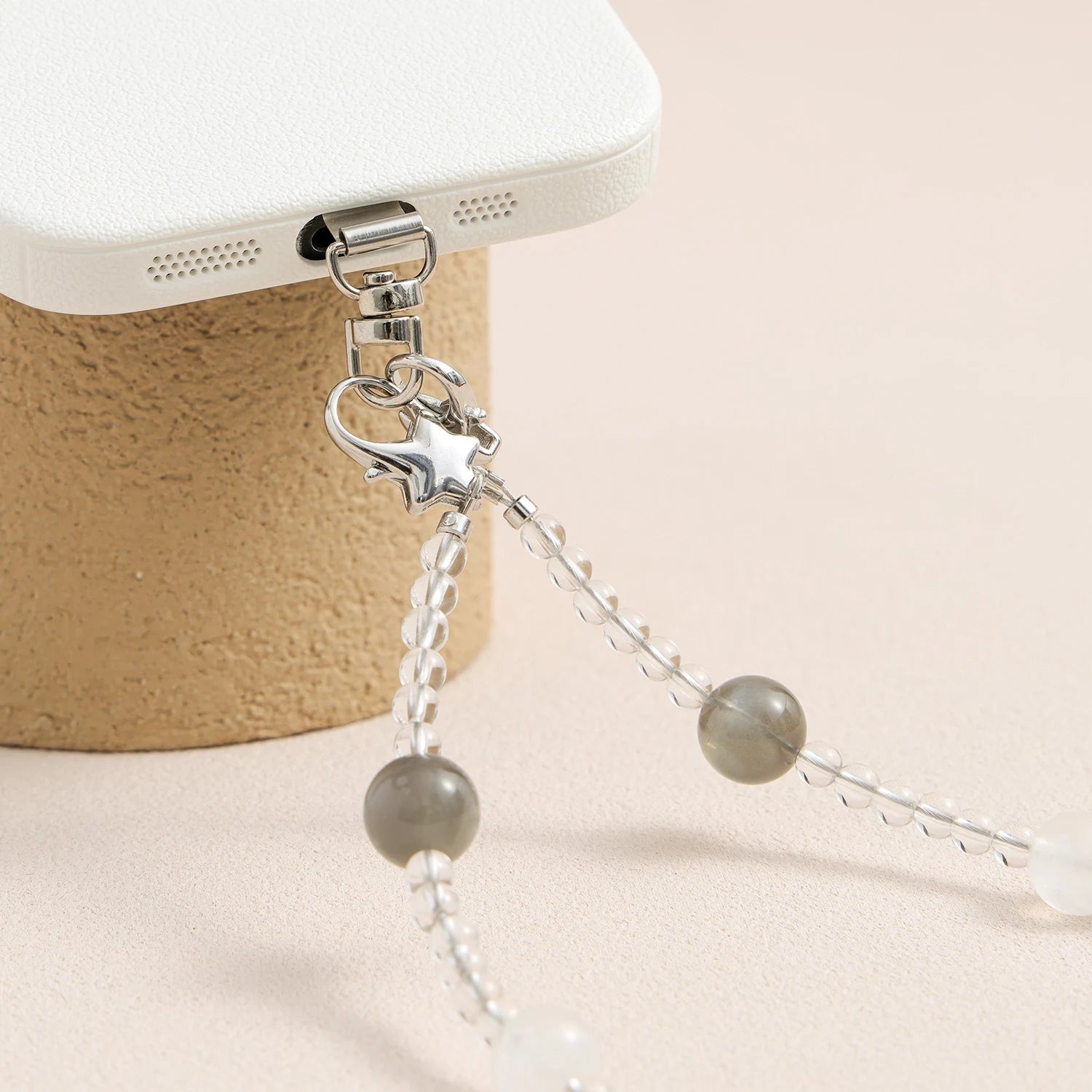 Grey moonstone, white quartz and peach moonstone gemstone phone strap with custom metal link clasp, handmade detachable bracelet phone strap on a neutral background.