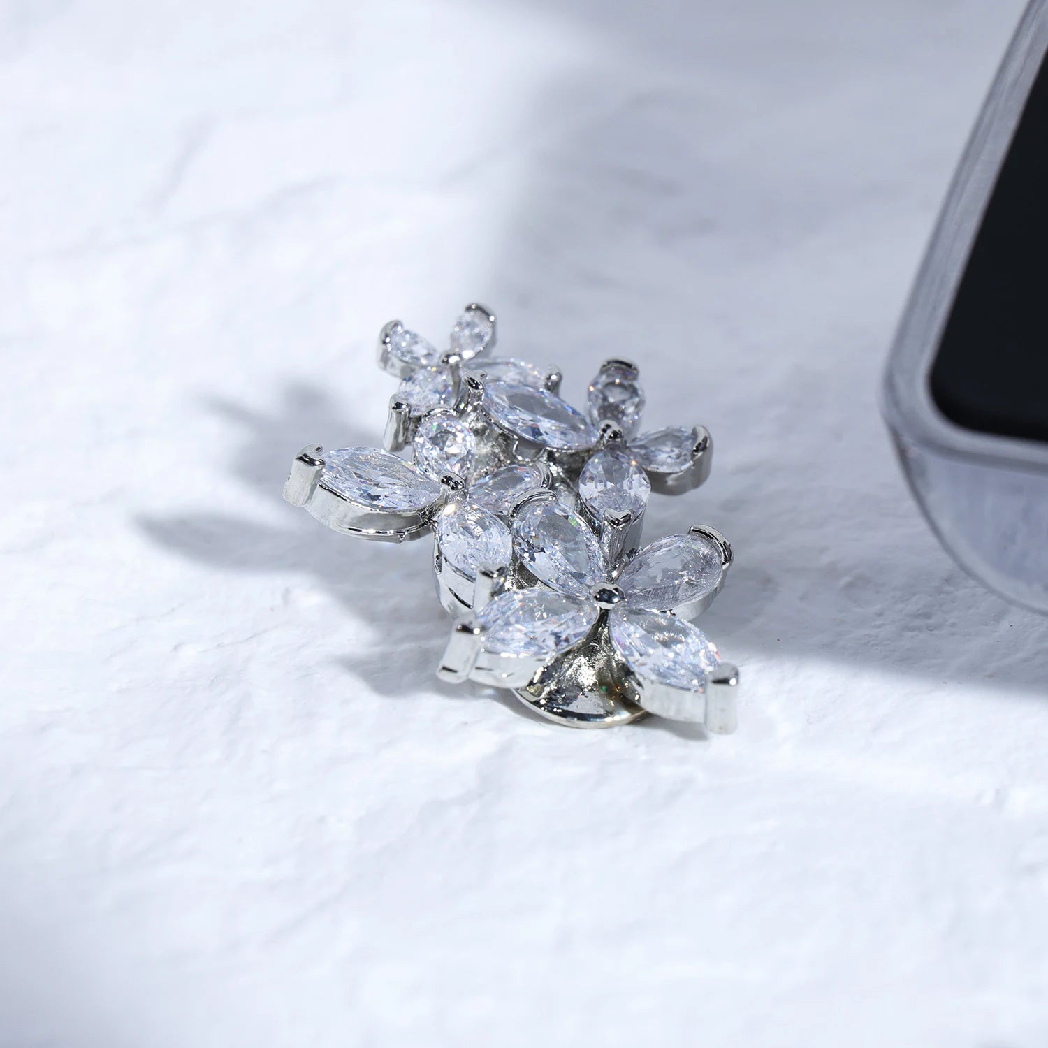 A silver crystal cluster ear charm inspired by celestial florals and Renaissance ornamentation. Designed for refined ear jewelry styling.