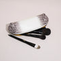 Open rectangular brow pencil pouch holding makeup brushes inside a structured leather case
