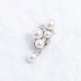 Close-up of a pearl and Swarovski crystal ear charm with starfall silhouette, silver-tone plated finish, and delicate drop pearl detail.