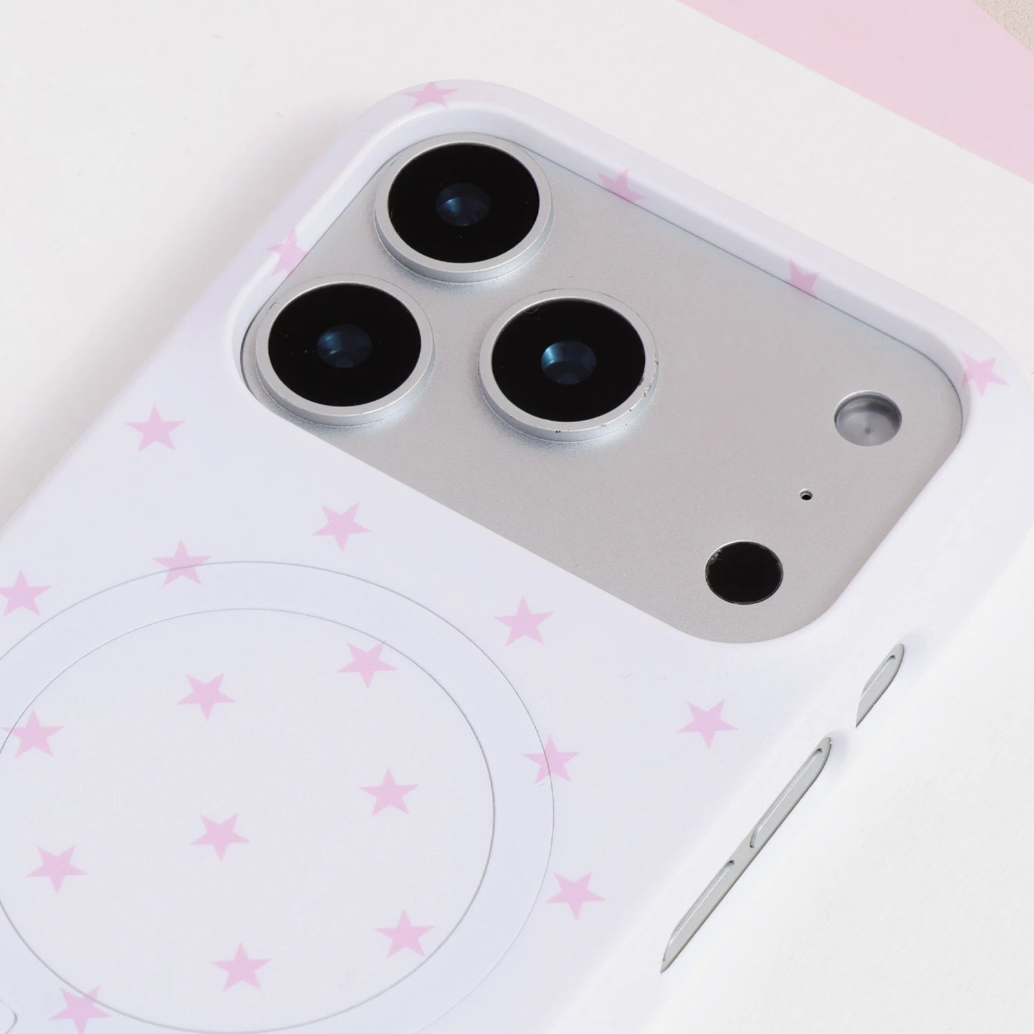 Close-up of the white starfall phone case camera area with soft pink star print and smooth PC finish.