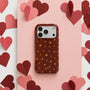 Deep red shimmering star phone case with gold stars on a pink heart-themed background