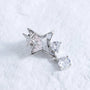 Silver-tone star ear charm with clear crystal drop on a white textured background