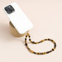 Tiger’s eye gemstone phone strap with gold metal accents, detachable bracelet design