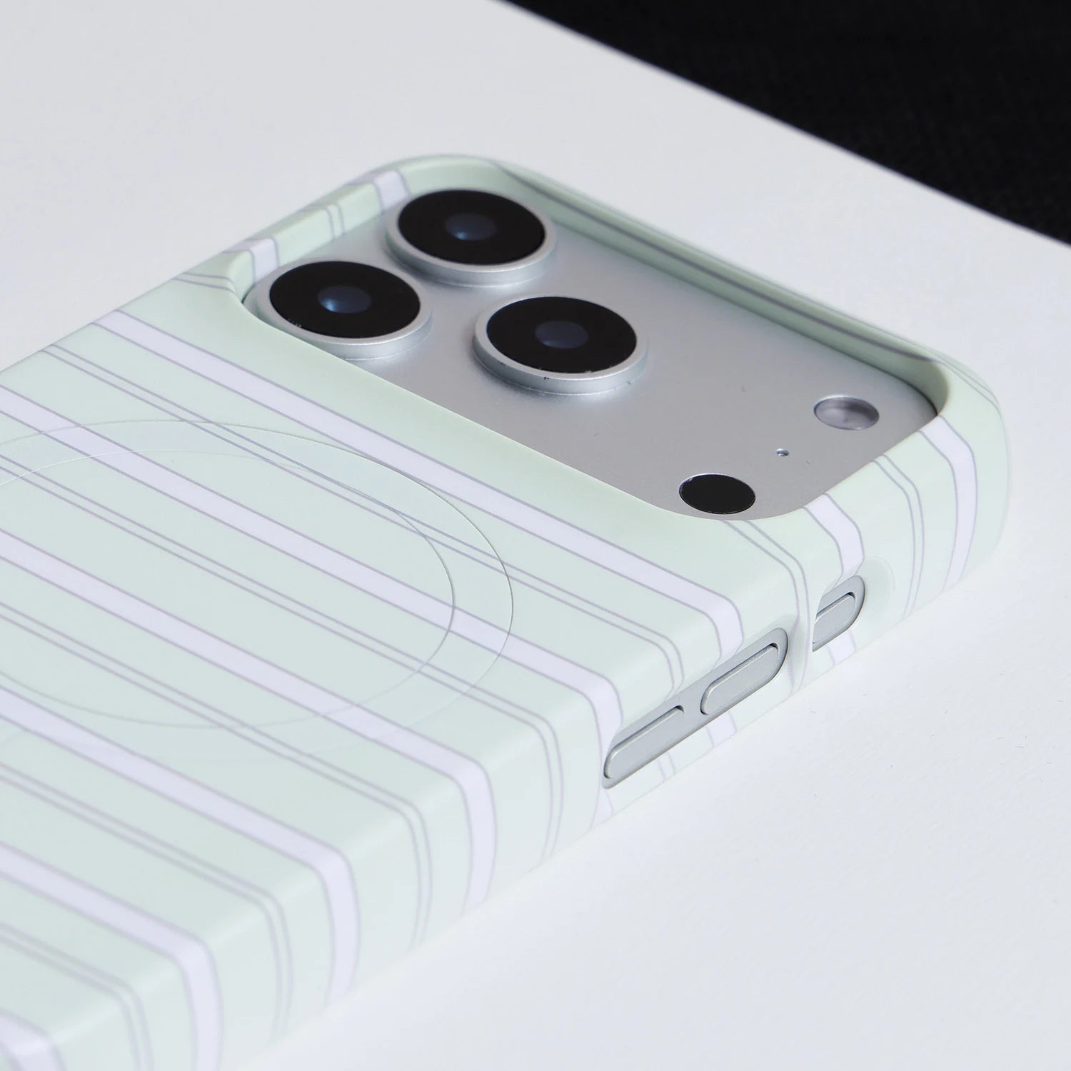 Close-up of mint striped phone case showing raised camera surround and striped hard-shell finish