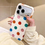 Close angled view of a multicolor polka dot phone case with raised camera surround