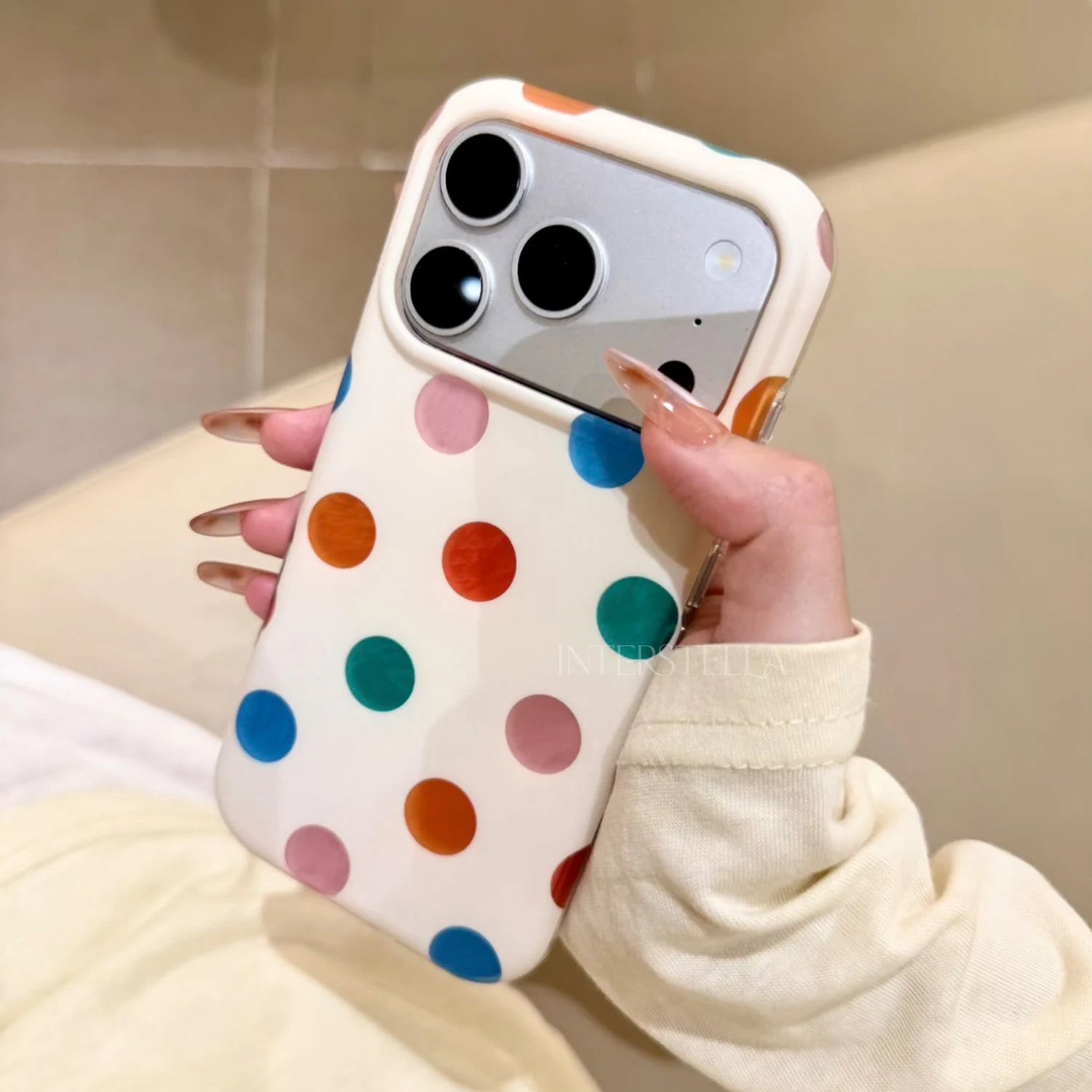 Close angled view of a multicolor polka dot phone case with raised camera surround