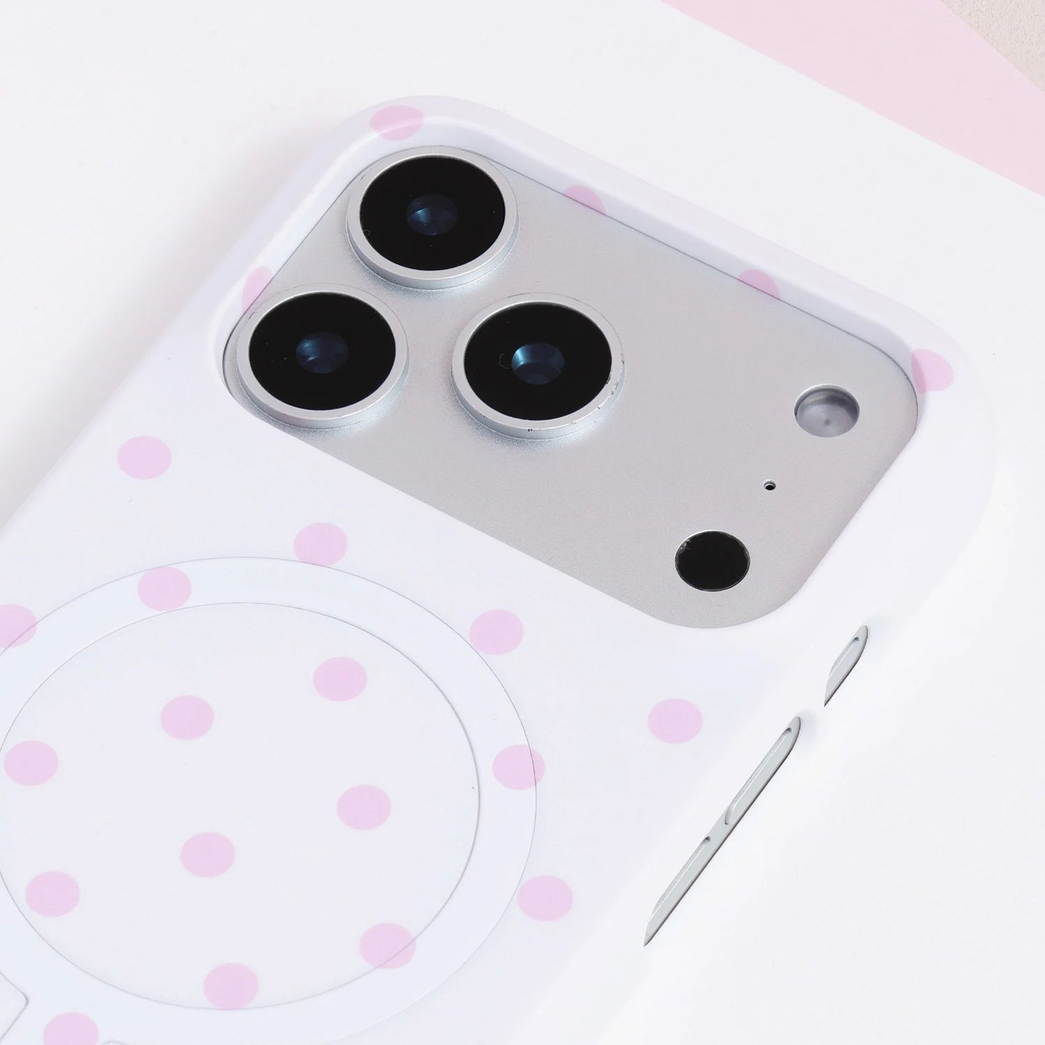 Close-up of the porcelain white polka dot card phone case camera area with large blush-pink dots and smooth PC finish.
