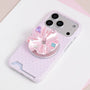 Pink jewel rosette phone grip stand mounted on a pale pink micro polka dot card-slot phone case.