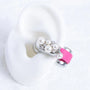 Pearl and Swarovski crystal ear charm attached to a pink Interstella Aura earbud and displayed on a white ear model.